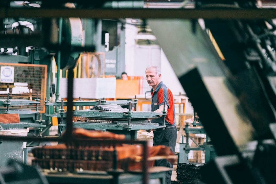 Man operating industrial machinery in a factory.